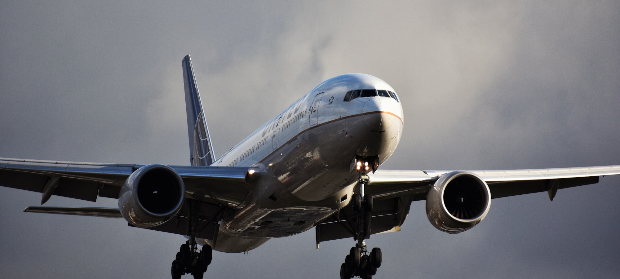 A wide-body aircraft on approach under an overcast sky
